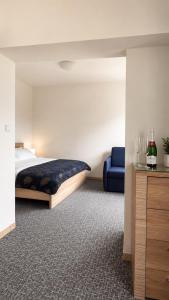a bedroom with a bed and a blue chair at Penzión Aurora Patince in Patince
