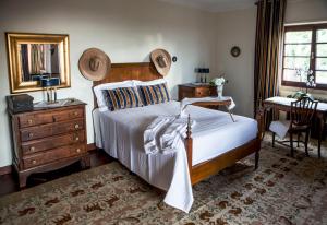 a bedroom with a bed and a desk and a mirror at Quinta Santo António in Sintra