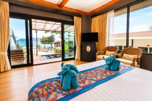 a bedroom with a bed with two elephants on it at Phi Phi Long Beach Resort & Villa in Phi Phi Islands