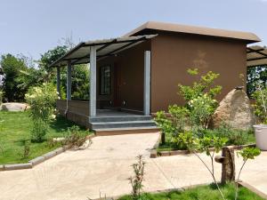a small house with a porch in a garden at Tutti Cafe in Hampi