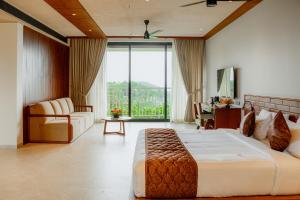 a bedroom with a large bed and a living room at Mountree Munnar by Kondody Hotels in Anachal +72 photos