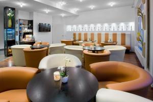 un restaurante con mesa negra y sillas naranjas en City Hotel Isar-Residenz en Landshut