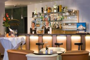 twee vrouwen aan een bar in een restaurant bij City Hotel Isar-Residenz in Landshut