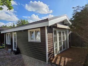 a tiny house with a pitched roof and windows at AMONG Nature Stay in Vilnius in Vilnius