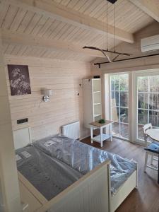 a bedroom with a bed in a room with wooden walls at AMONG Nature Stay in Vilnius in Vilnius