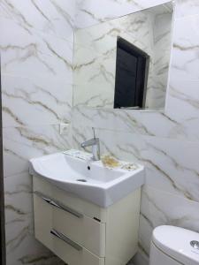a white bathroom with a sink and a mirror at Kut Hotel in Karakol +33 photos