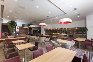 a restaurant with tables and chairs in a cafeteria at Staybridge Suites Birmingham by IHG in Birmingham