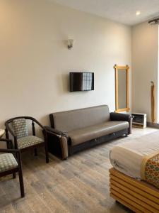 a room with a couch and a chair and a bed at Sky view Resort Shogran in Shongran