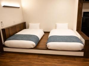 two beds sitting on a wooden shelf in a room at 風の音 in Motobu