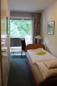 a hotel room with a bed with a yellow towel on it at Waldpension Bielefeld in Bielefeld