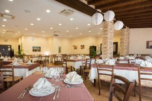 a restaurant with tables and chairs with white napkins at Valle Himara in Piana degli Albanesi