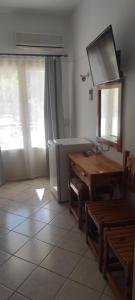 a kitchen with a table and a desk and a mirror at Ariadni Fountas Studios in Parga