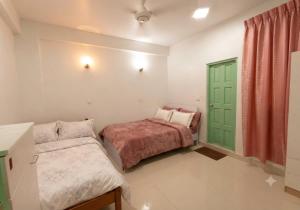 a bedroom with a bed and a green door at MSM DIAMOND guesthouse 1 in Male City