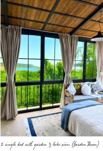a bedroom with a bed and large windows at Laklouk 1808 Lodge by Hansa in ‘Ayn aş Şalīb
