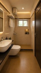 a bathroom with a white sink and a toilet at Heritage Garden in Bānsjora