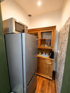 a kitchen with a stainless steel refrigerator and a wooden cabinet at Danielówka in Ciemiętniki