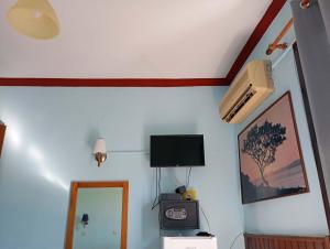 a room with a tv and a clock on a wall at samos town hostel in Samos