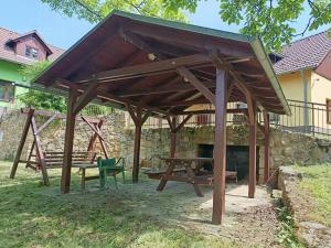 a wooden pavilion with a picnic table and a bench at Na pasekách u lesa apartmán Radost in Osvětimany