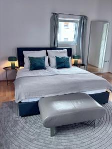 a bedroom with a large bed with a bench on it at PaderCityLoft Apartment Pfau in Paderborn +1 photo