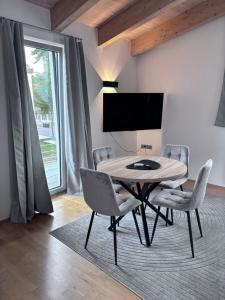 a dining room with a table and chairs and a tv at PaderCityLoft Apartment Pfau in Paderborn