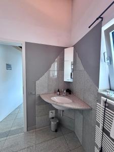a bathroom with a sink and a staircase at PaderCityLoft Apartment Pfau in Paderborn