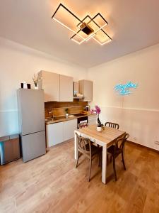 a kitchen and dining room with a table and a refrigerator at Faraglioni Bay in Acitrezza