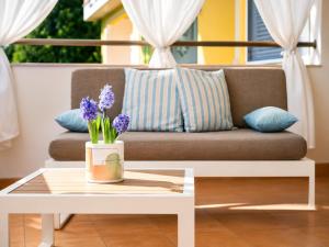 a living room with a couch and a table with purple flowers at Quiet Home in Pula