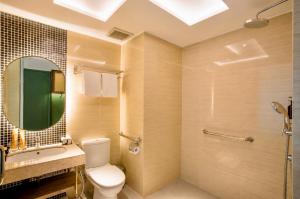 a bathroom with a toilet and a sink and a mirror at Elais by ARTOTEL in Medan +15 photos