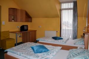 a room with two beds with blue pillows on them at Penzion Gostilna Keber in Domžale