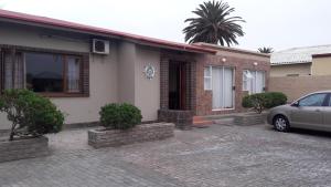 una casa con un coche aparcado delante en Skippers Backpackers CC, en Walvis Bay