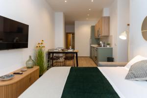 a bedroom with a large bed and a kitchen at Apartamentos Liérganes Centro II in Liérganes