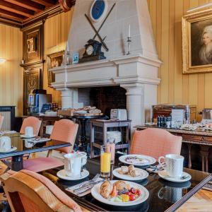 a table with plates of food on it with a fireplace at Château De Pray in Amboise +34 photos