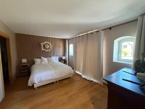 a bedroom with a white bed and a window at gîte du bel étang in Commenailles