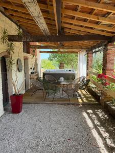 a patio with a table and chairs on a deck at gîte du bel étang in Commenailles