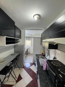 a small kitchen with black cabinets and a sink at Comfy Flat in New Belgrade in Belgrade