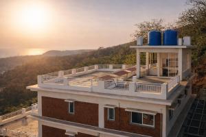 a building with two blue water tanks on top of it at Anandi Hotel Guhagar in Guhagar