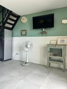 a room with a fan and a tv on the wall at Island House Rentals 40 in Ko Samed