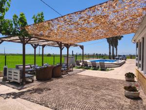 a pavilion with tables and chairs and a pool at Mas Panoli in Deltebre +74 photos