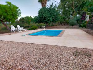 a swimming pool with a table and chairs in a yard at Estudio "La Cochera de Sorrapa" in Deltebre