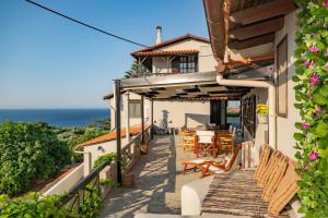 a house with a balcony with a view of the ocean at Agnanti Seaview Villa in Karlovasi