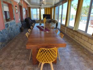 a long wooden table with chairs in a room with windows at Mas Panoli in Deltebre