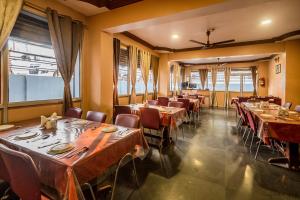 a dining room with tables and chairs and windows at Laxman Avenue in Jagdalpur +52 photos