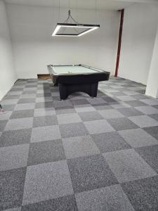 an empty room with a pool table on a checkered floor at Góralski Apartament in Szaflary