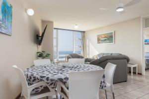 a dining room with a table and chairs and a couch at Peacehaven 108 in Scottburgh