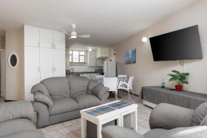 a living room with a couch and a tv at Peacehaven 108 in Scottburgh