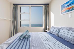 a bedroom with a bed and a large window at Peacehaven 108 in Scottburgh +23 photos
