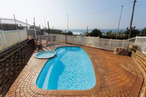 a large blue swimming pool on a brick patio at Peacehaven 108 in Scottburgh