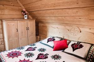 a bedroom with a bed with a wooden wall at Domek Regionalny KUBUŚ in Zakopane