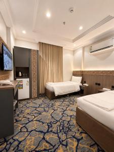 a hotel room with two beds and a television at Luluat Al Badaie Hotel in Mecca +18 photos