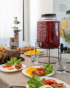 a table with plates of food and a jar of jam at Hotel Embassy in Pesaro